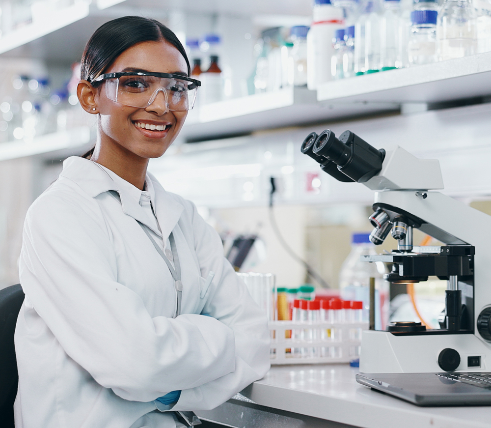 woman on microscope with arms crossed in lab